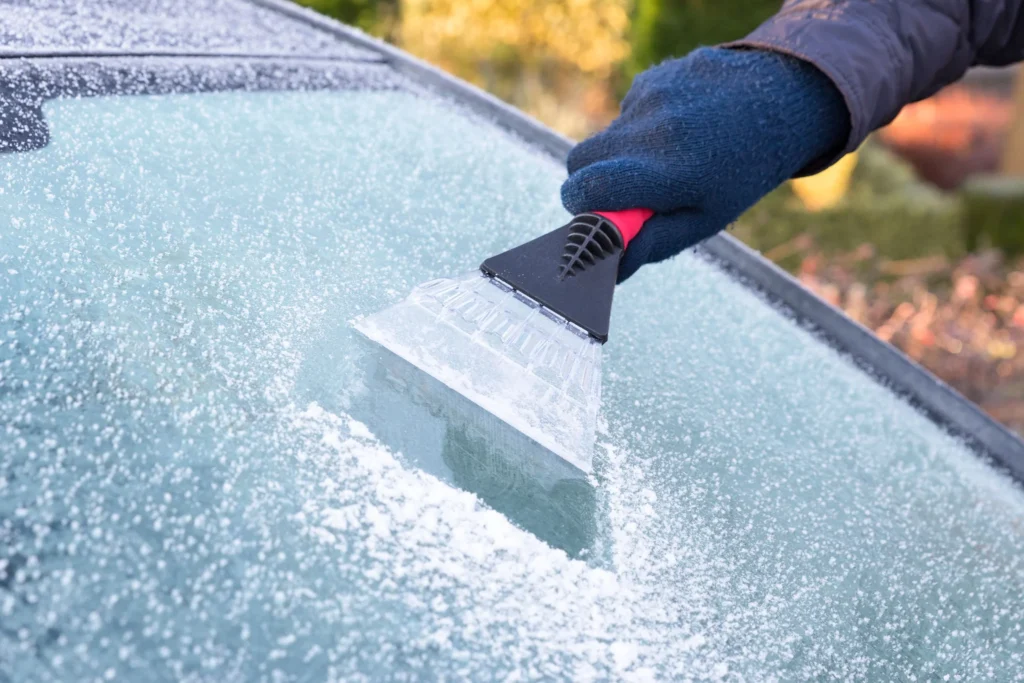 Using an ice scraper to show how to remove ice from a windshield