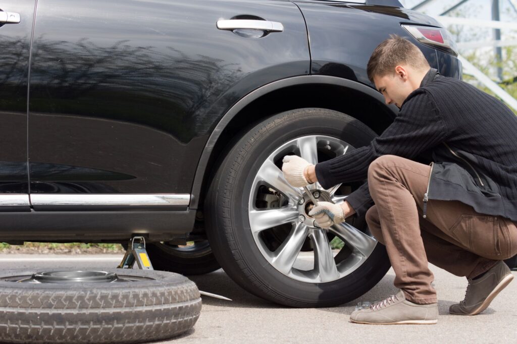 Demonstrating how to fix a flat tire on the roadside